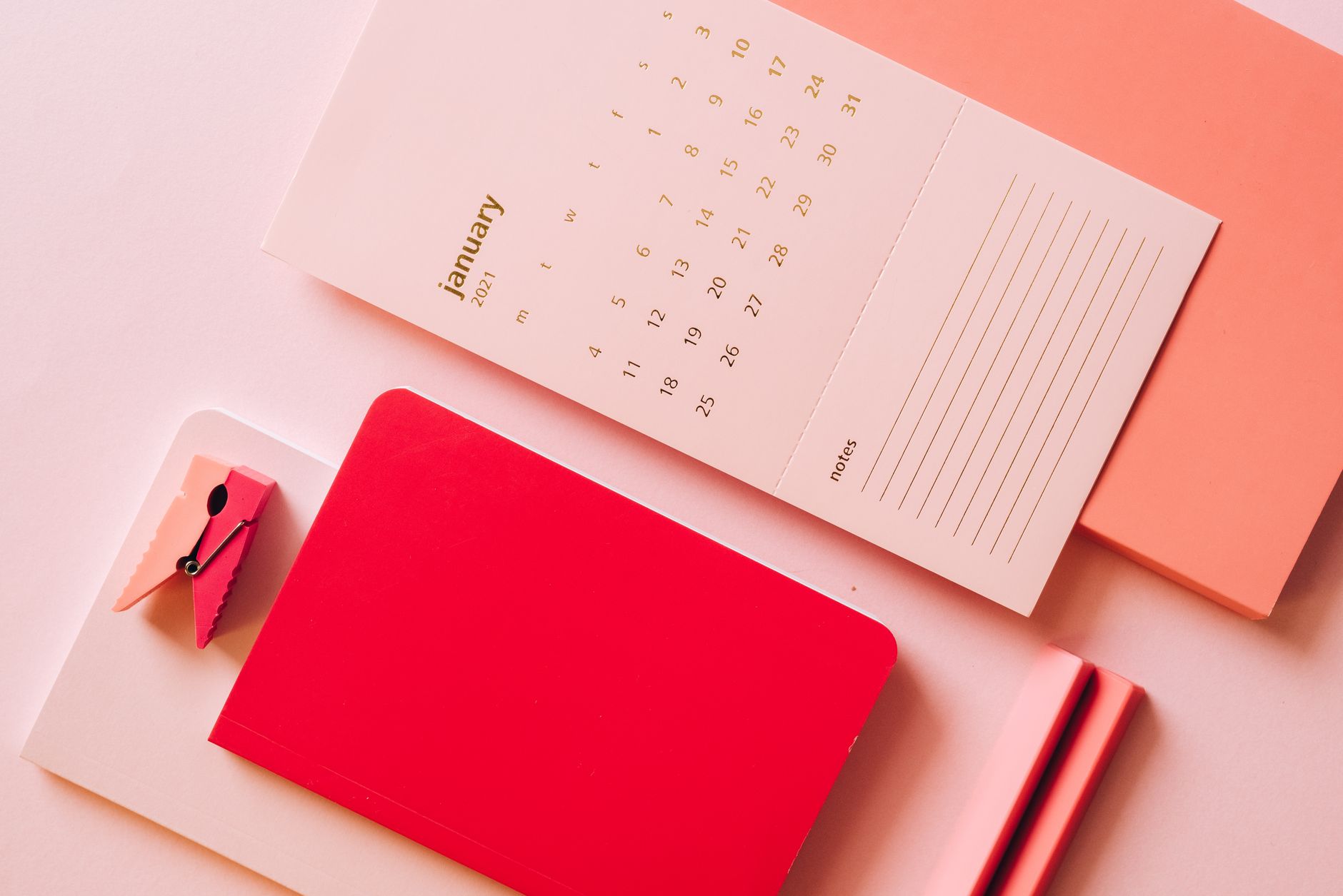 Calendar and notebook on a desk used to plan a campaign timeline.