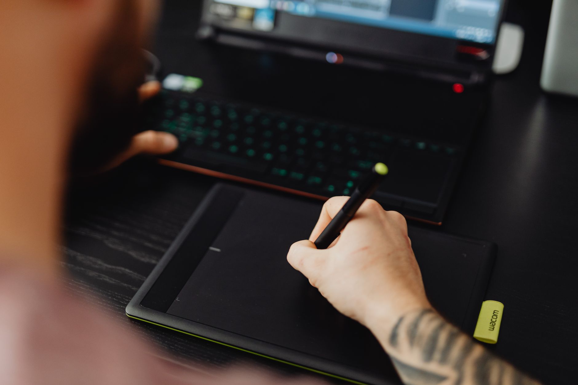 Open laptop next to a tablet and stylus on a white background