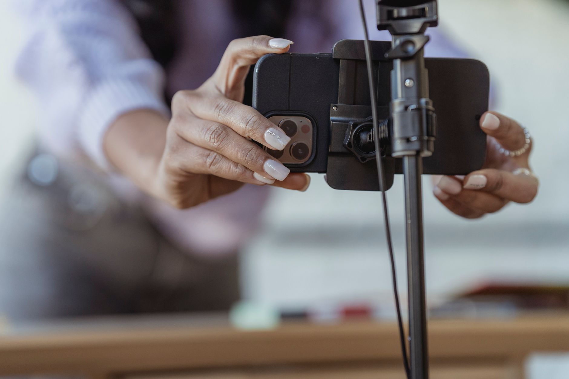 A bakery owner filming pastries on a counter with a smartphone.