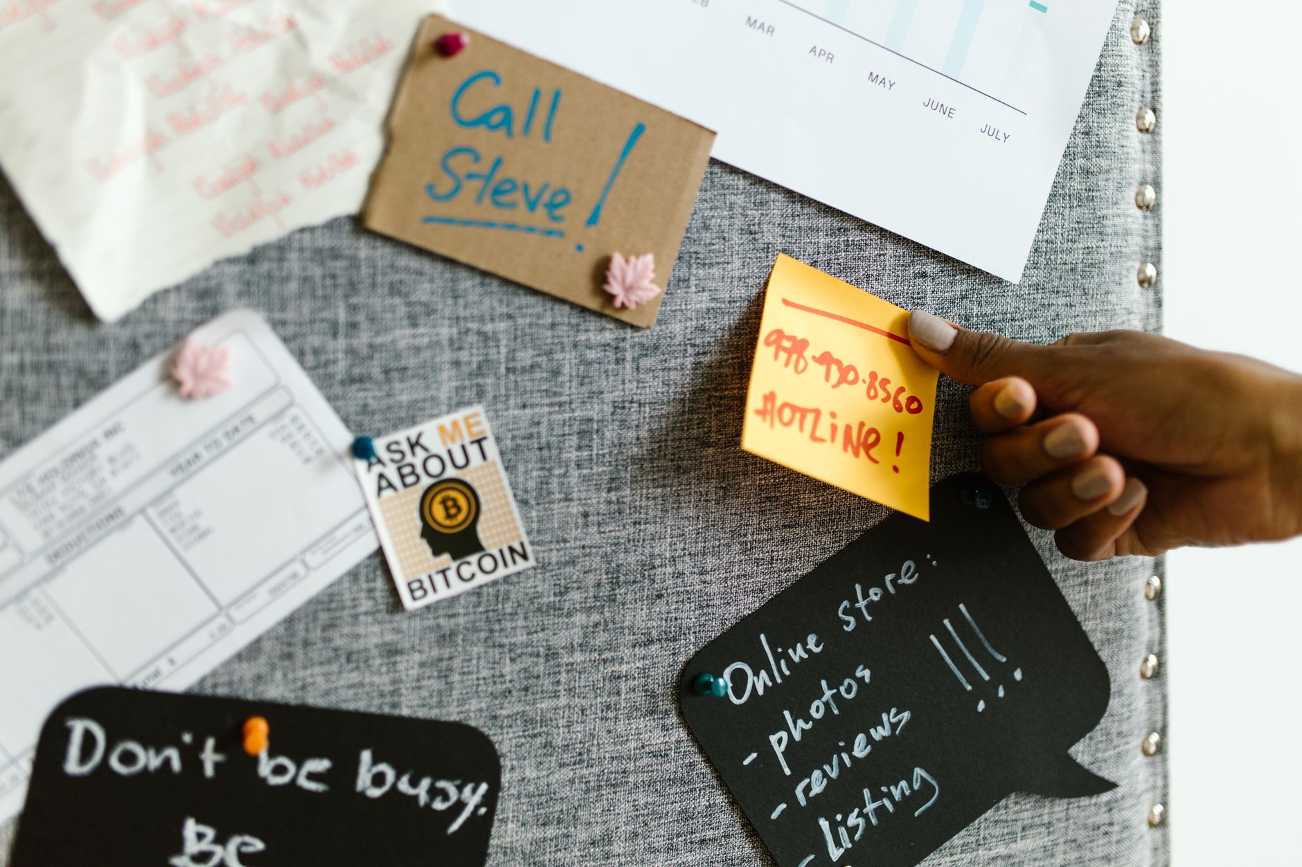A marketer organizing printed notes on a corkboard.