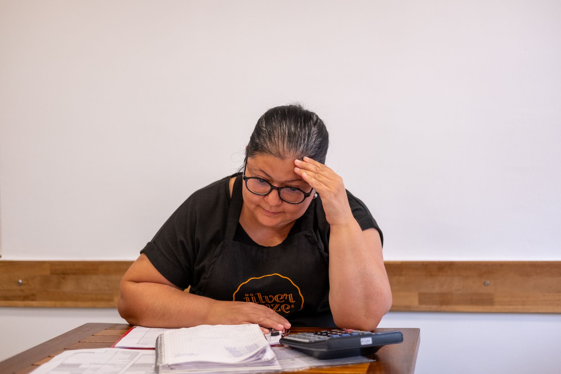 Small business owner reviewing costs at a laptop