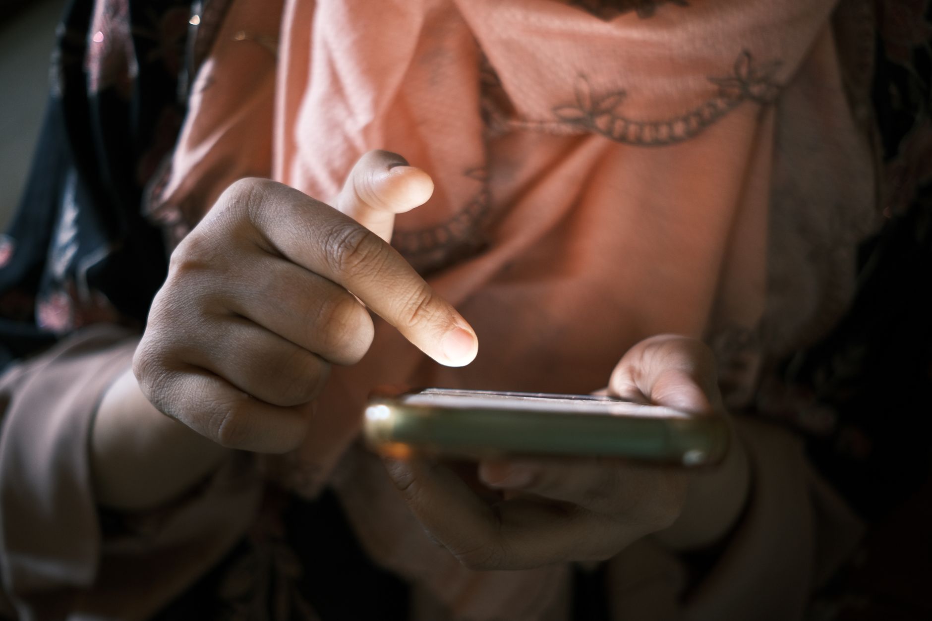Close-up of a thumb swiping on a phone screen